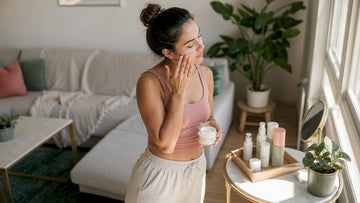 Woman applying moisturizer in bedroom vanity
