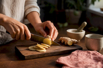 Hands slicing fresh ginger for nausea support
