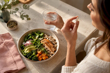 Woman taking probiotic with a meal