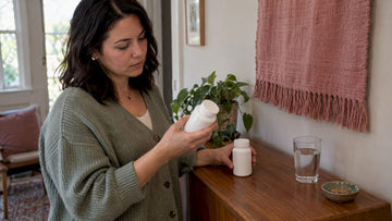 Woman comparing probiotic supplement bottles