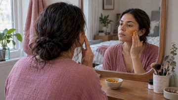 Woman applying turmeric paste to cheek