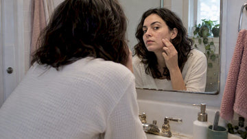 Woman examining mild blemishes in mirror