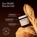 Jar of 'arrae Bloat' supplement with bread on a dark background